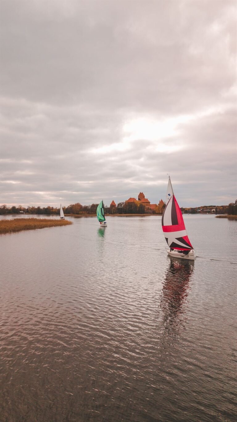 Jachta su raudona bure, tolumoje Trakų pilis